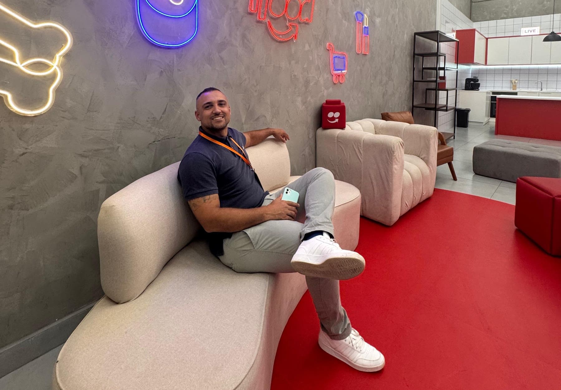 Claudio Beloti sentado num sofá dentro de um escritório de plataforma de delivery